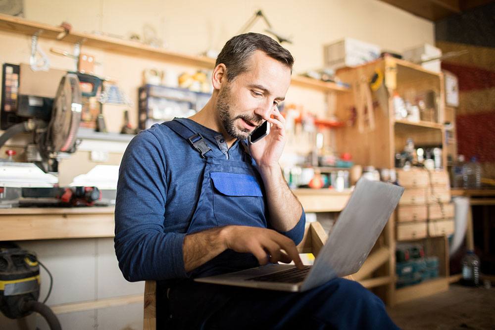Business banking customer on the phone and on his computer