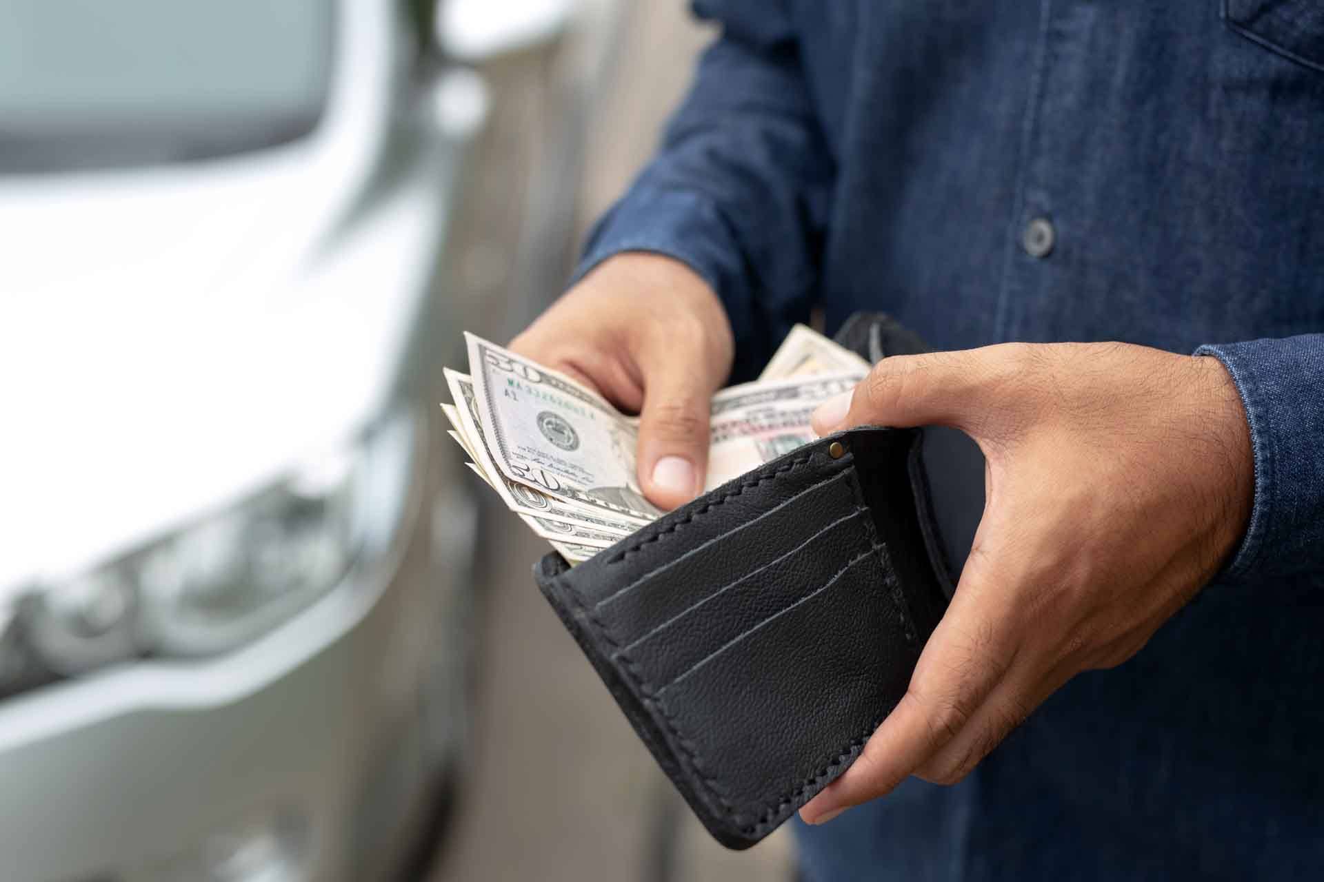 A person taking money out of their wallet.
